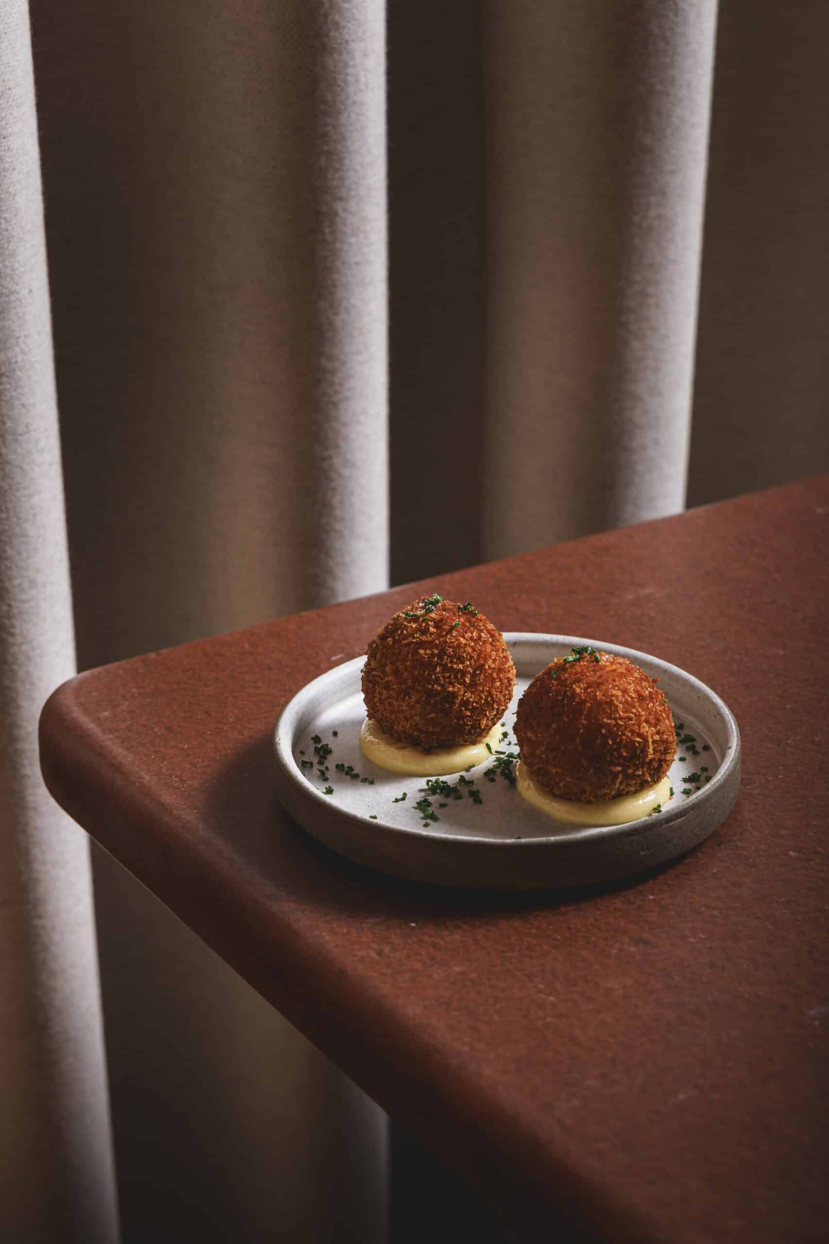 Speck croquettes served on a ceramic plate at Ara Restaurant in Aldgate East, near Spitalfields and Shoreditch.