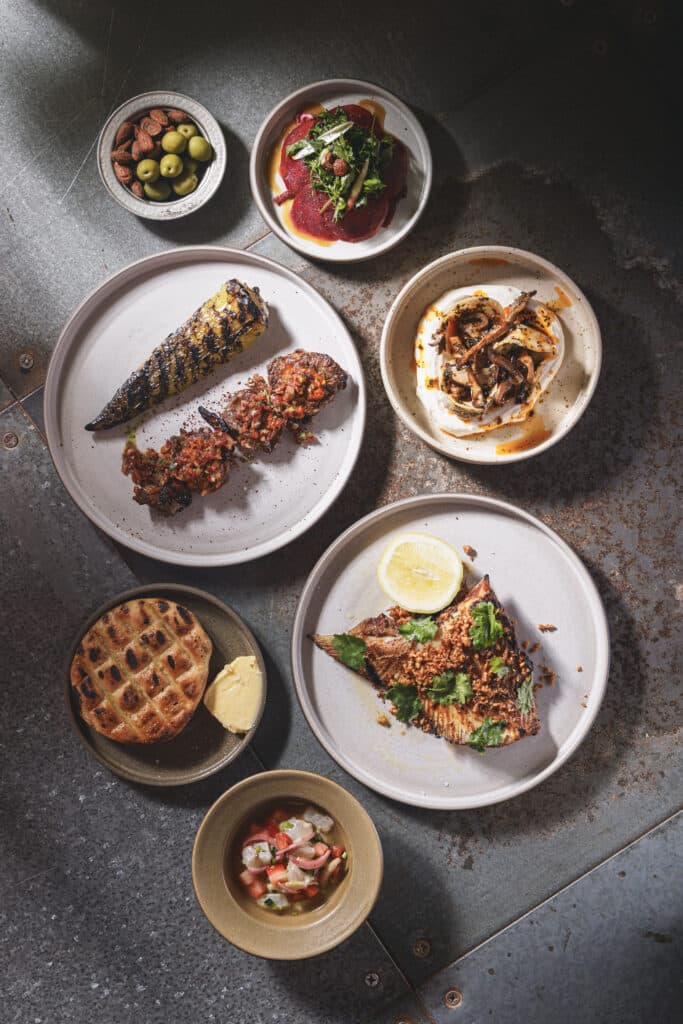 Well travelled small and large plates including grilled skate wing, mushroom dumplings, and lamb skewers at Ara Restaurant in the City of London, near Whitechapel.